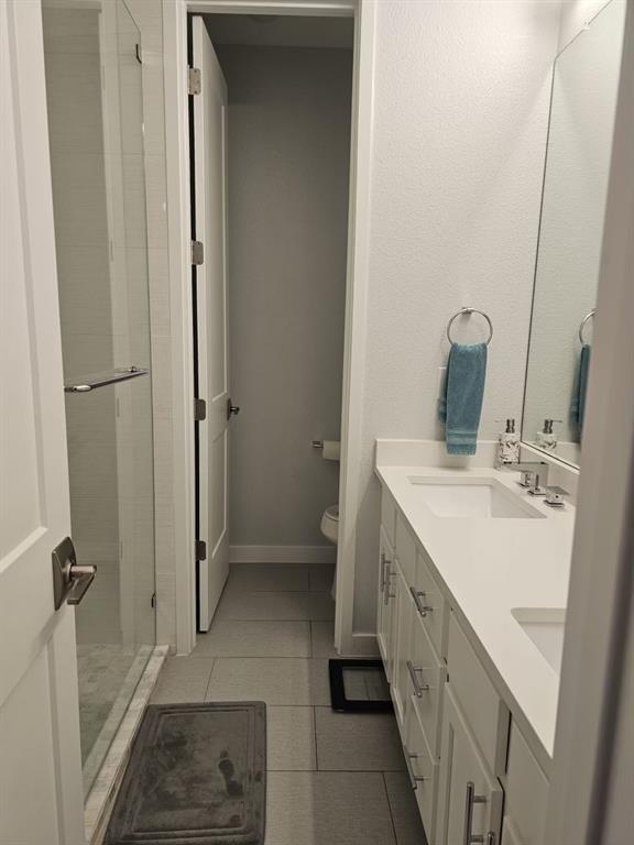 6004 Hudson Street, Unit 104 Dallas, TX 75206 - Photo 12 of 16 a bathroom with a double vanity sink and a mirror