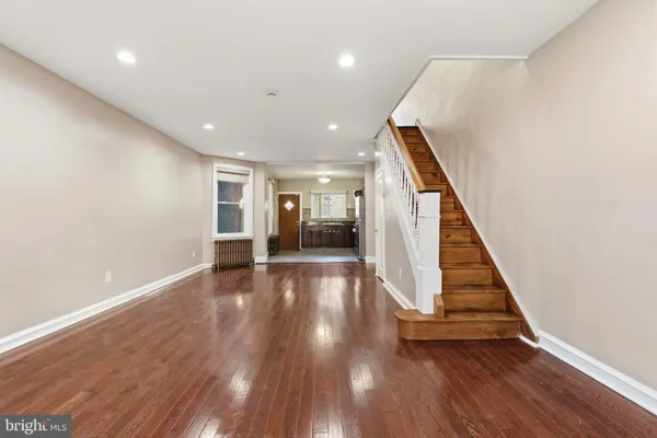 a view of a hallway with wooden floor and staircase