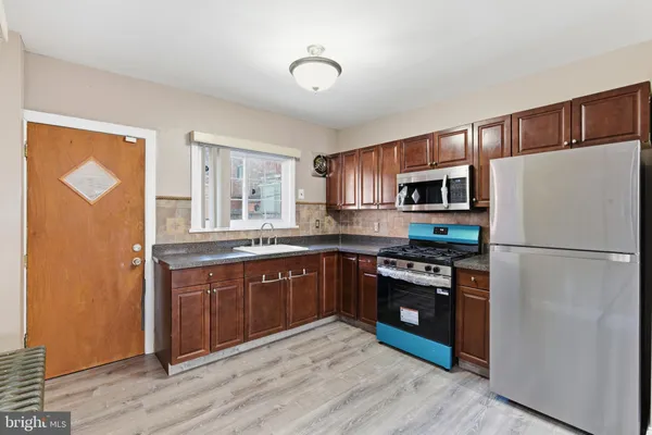 a kitchen with stainless steel appliances granite countertop a refrigerator stove and sink