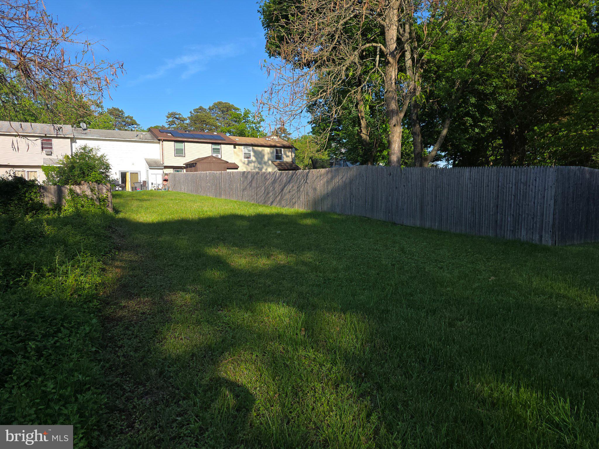 27 Berkshire Road Sicklerville, NJ 08081 - Photo 6 of 7 Spacious green yard with wooden fence.