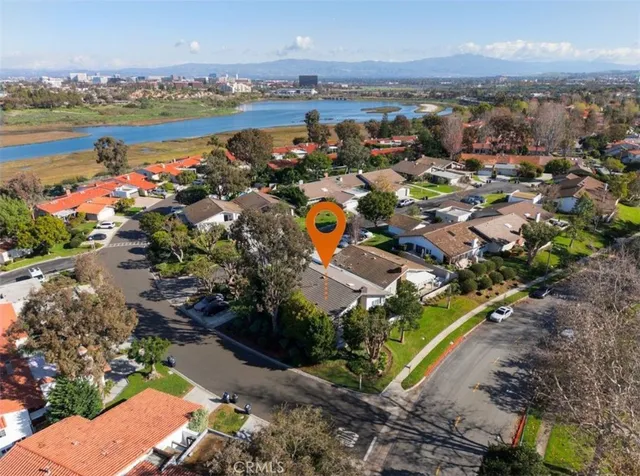 an aerial view of a city with lots of residential buildings ocean and mountain view in back