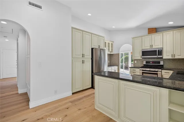 a view of an empty room with wooden floor fireplace and a window