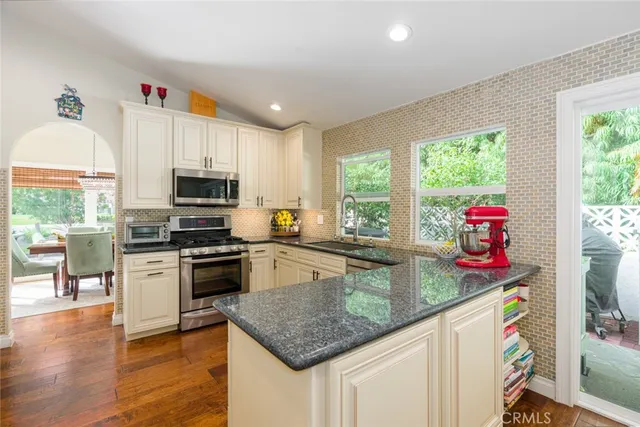 a kitchen with stainless steel appliances granite countertop a refrigerator a stove a sink and a granite counter tops