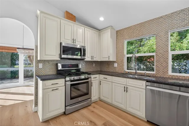 a kitchen with white cabinets and a stove top oven