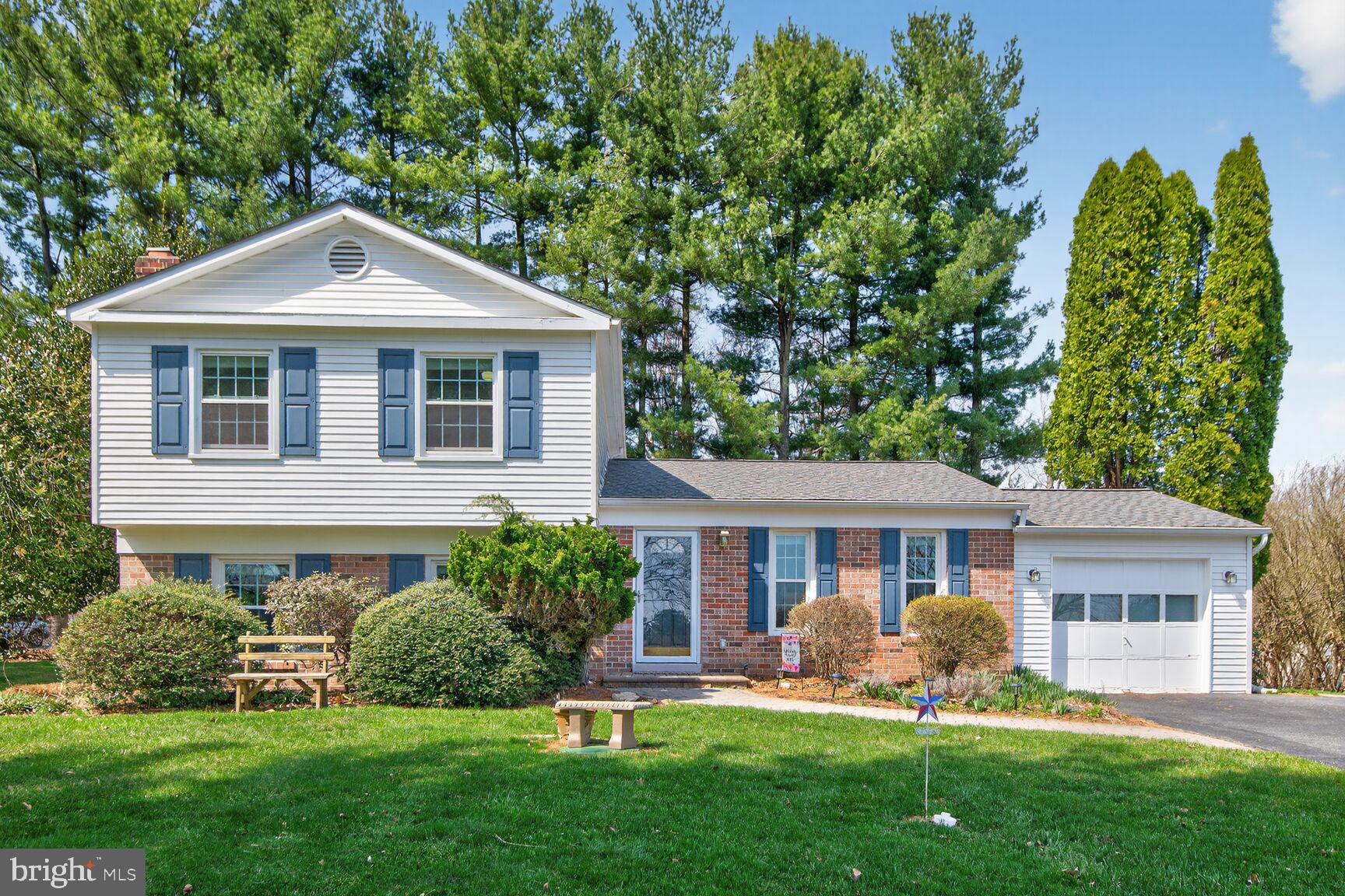 a front view of a house with a yard and green space