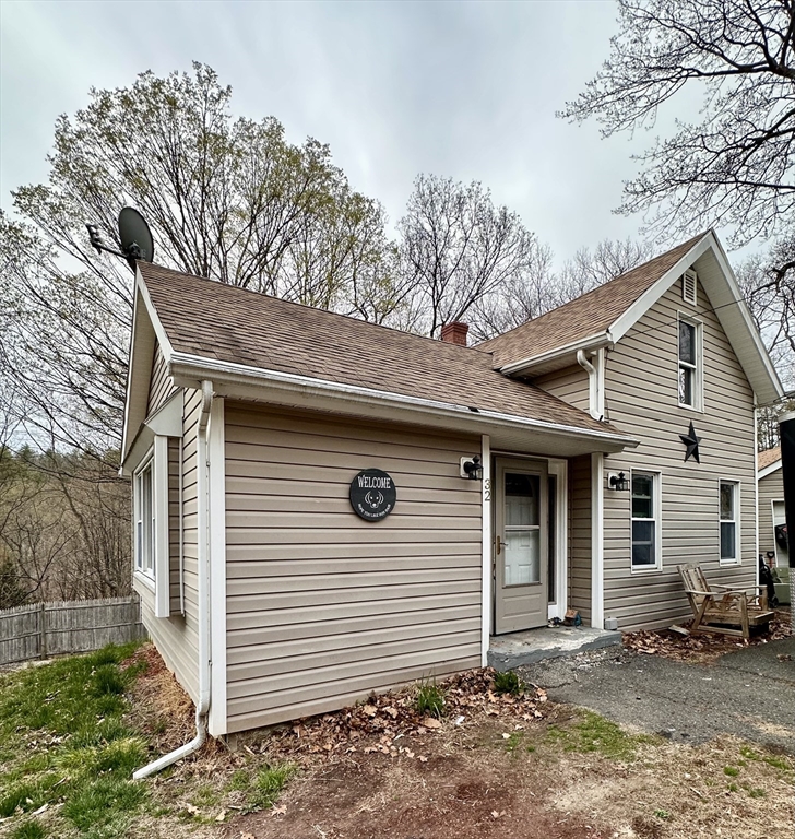a front view of a house with a tree