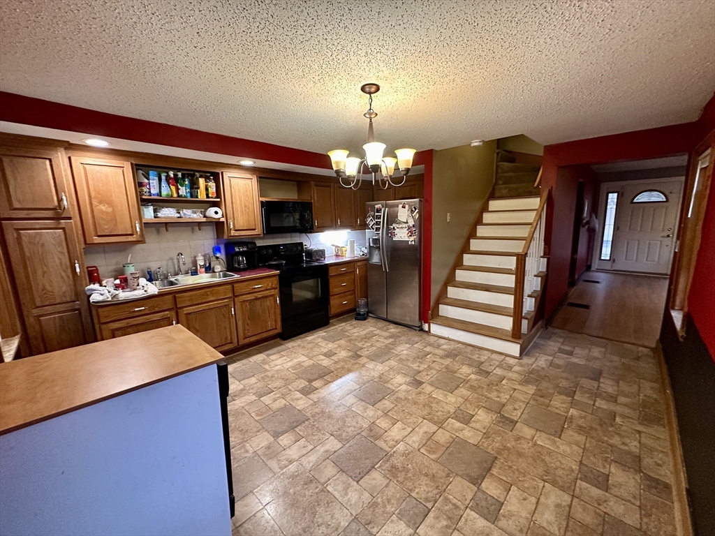32 High Street Erving, MA 01344 - Photo 3 of 11 a large kitchen with granite countertop a stove refrigerator and a sink