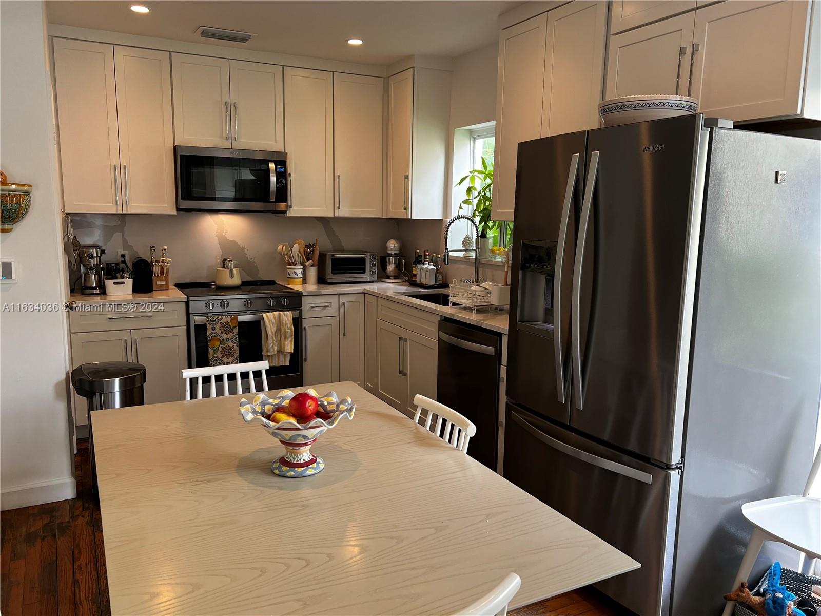 454 Southwest 25th Road Miami, FL 33129 - Photo 11 of 33 a kitchen with stainless steel appliances a refrigerator stove microwave and cabinets