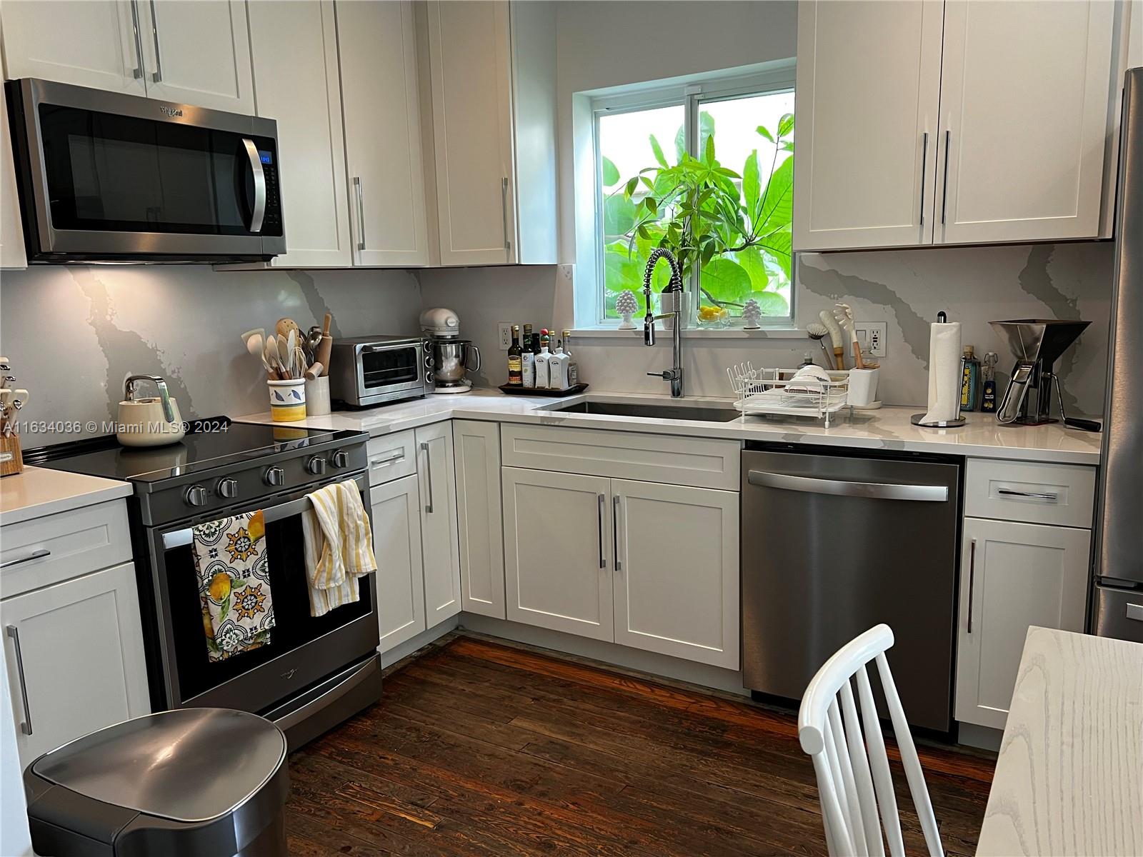 454 Southwest 25th Road Miami, FL 33129 - Photo 8 of 33 a kitchen with stainless steel appliances a stove a sink a microwave and cabinets