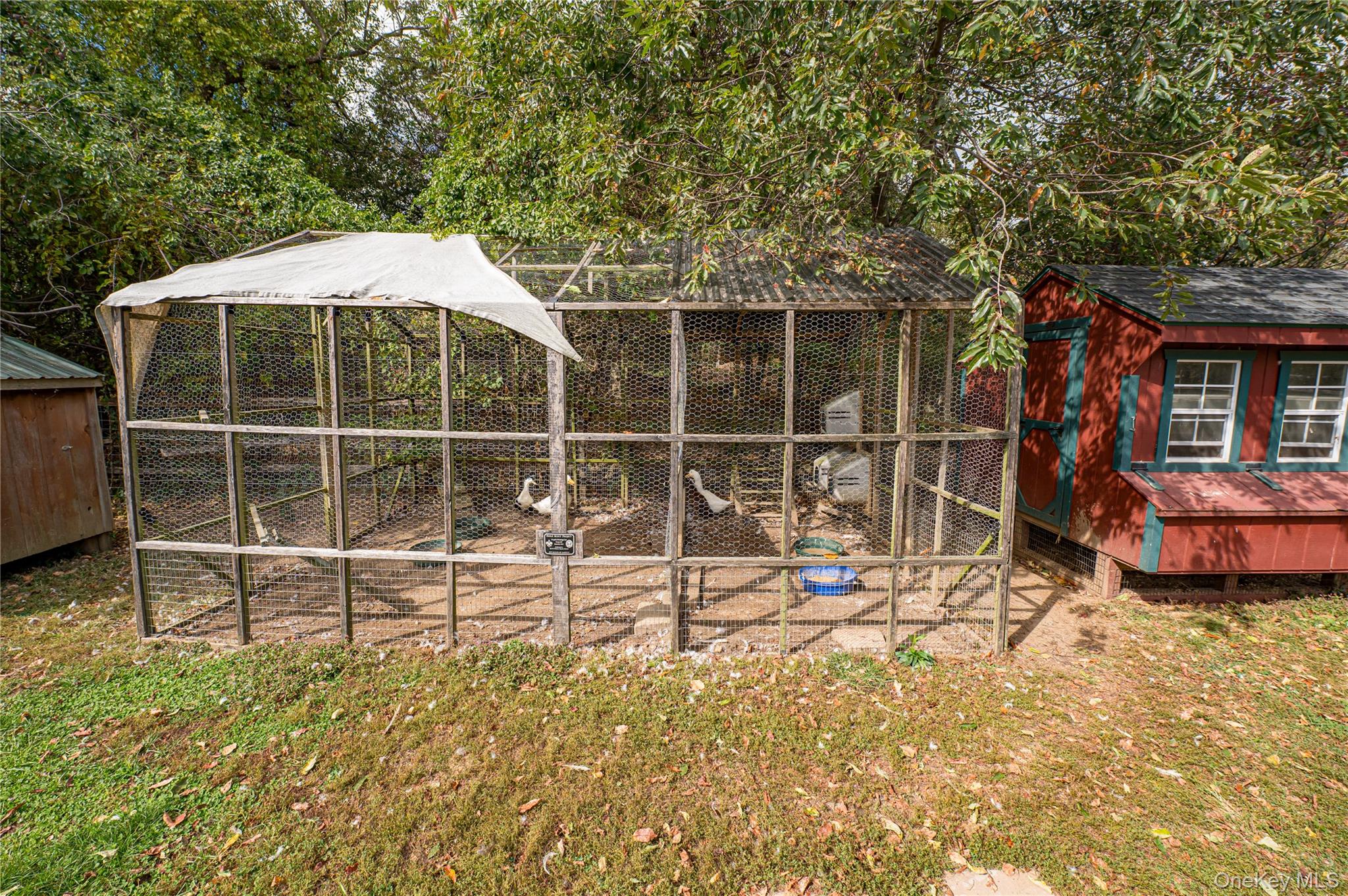 2746 Sound Avenue Riverhead, NY 11901 - Photo 28 of 44 a view of a backyard with table and chairs and wooden fence