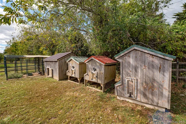 a view of a house with a yard and large tree
