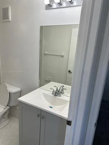 a bathroom with a sink a toilet and a mirror
