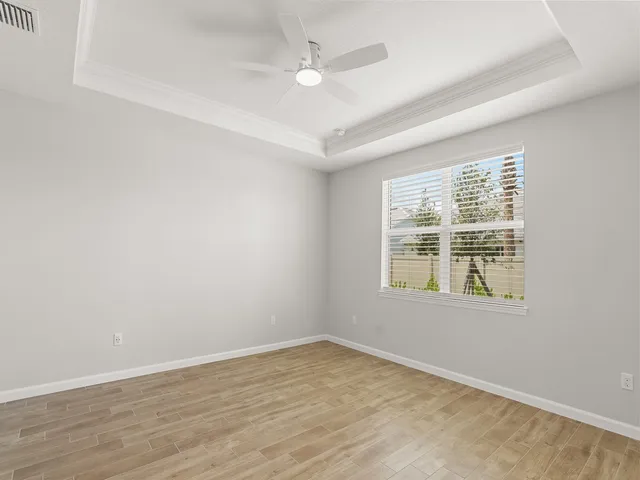 an empty room with a window and a ceiling fan
