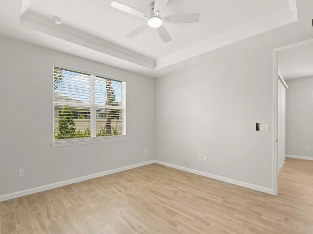 an empty room with a window and a ceiling fan