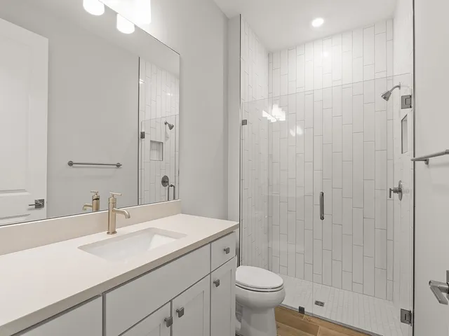 a bathroom with a sink a toilet and shower