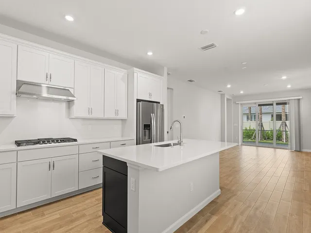 a kitchen with stainless steel appliances granite countertop a sink a stove a refrigerator and cabinets