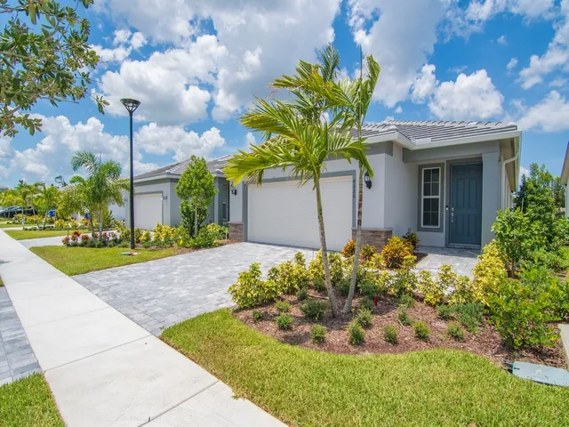 a front view of a house with a yard and a garden
