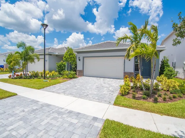 a front view of a house with a yard and fountain