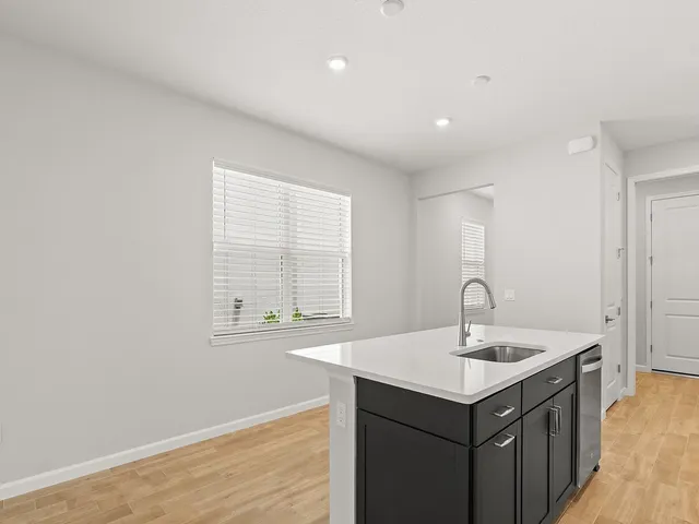 a kitchen with a sink cabinets and a wooden floor