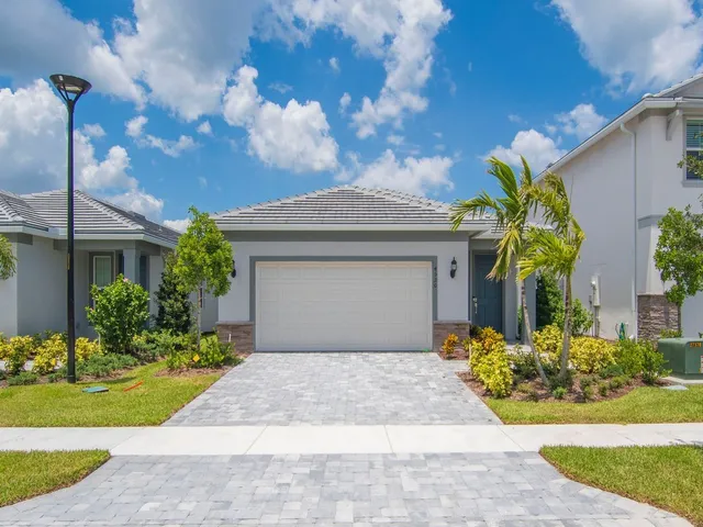 a front view of a house with a garden and plants