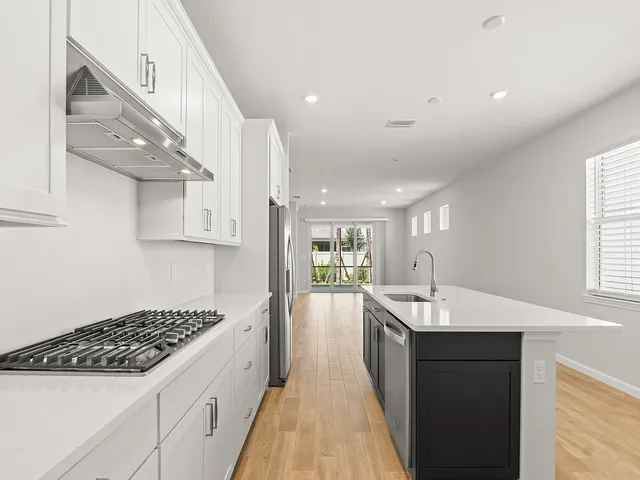 a large white kitchen with a large window