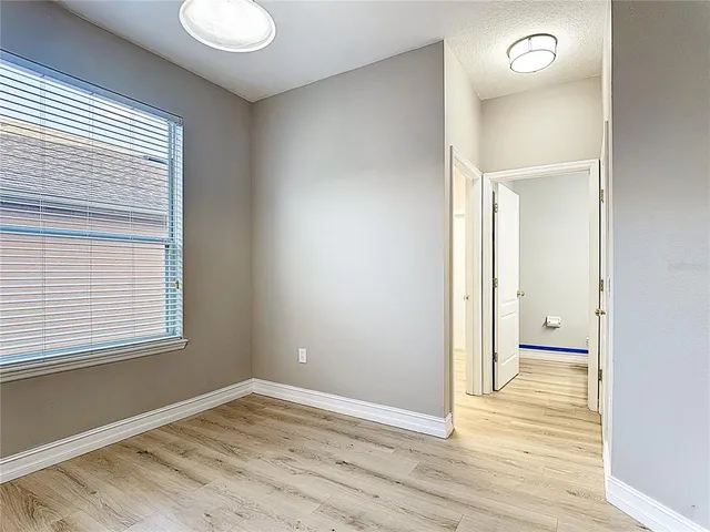 a view of a big room with windows and chandelier fan