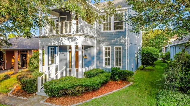 a view of a brick house with a yard and plants