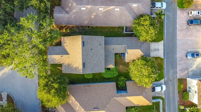 an aerial view of residential houses with outdoor space and trees