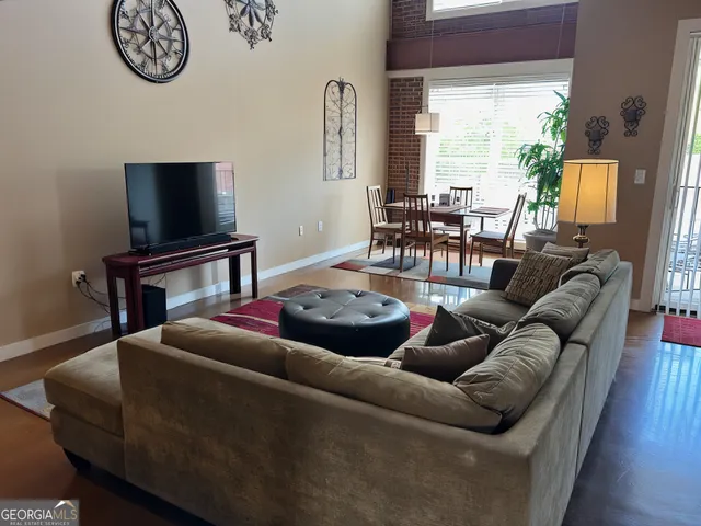 a living room with furniture a large window and a flat screen tv