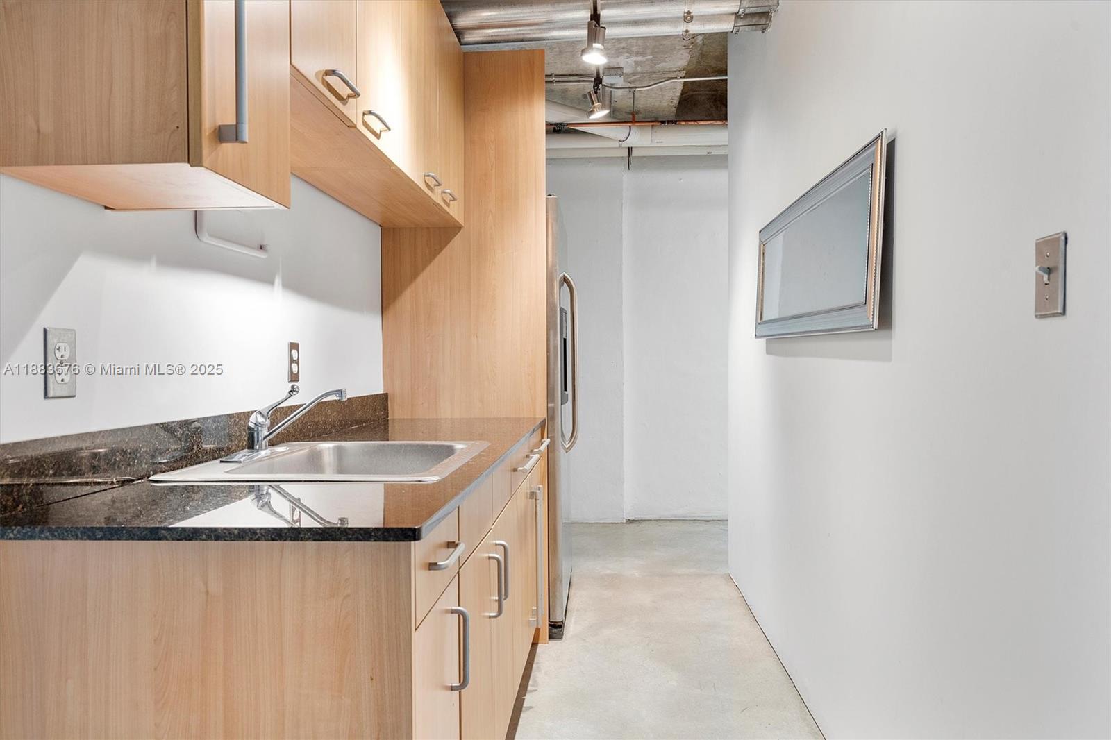 8101 Biscayne Boulevard, Unit R515 Miami, FL 33138 - Photo 19 of 26 a kitchen with a sink a refrigerator and cabinets