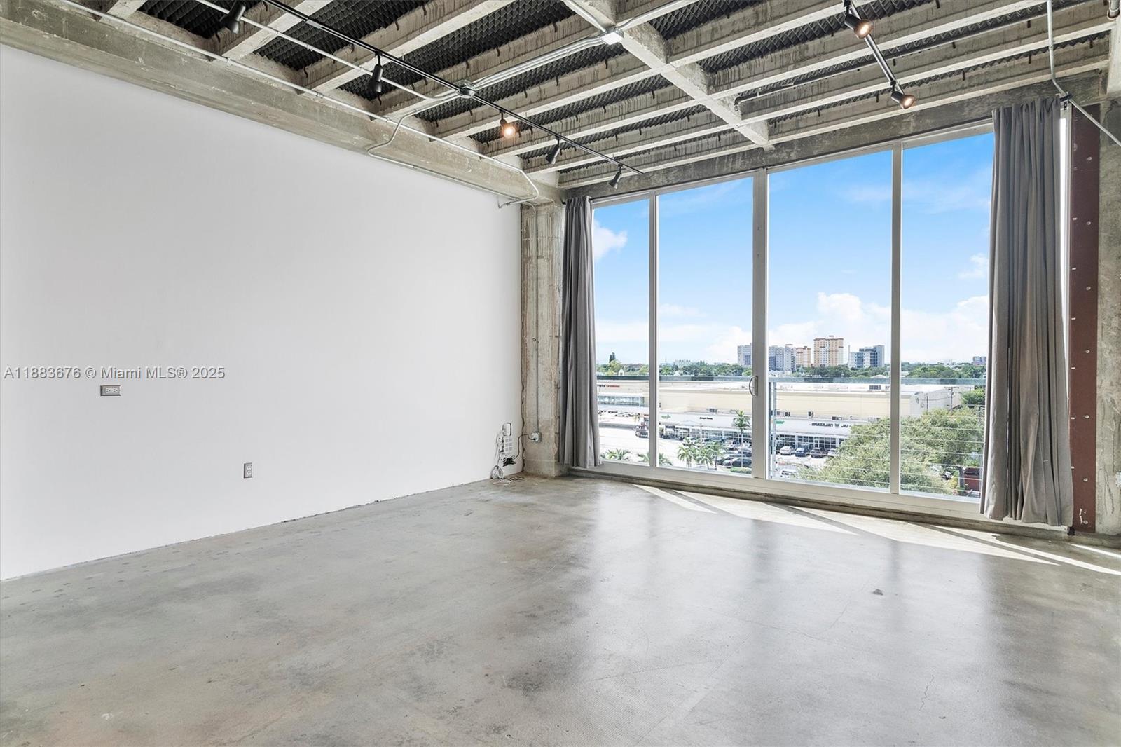 8101 Biscayne Boulevard, Unit R515 Miami, FL 33138 - Photo 3 of 26 an empty room with wooden floor and windows