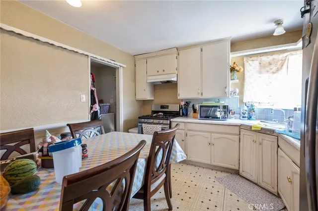 a kitchen with a table chairs stove and cabinets
