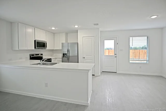 a kitchen with stainless steel appliances a refrigerator sink and microwave