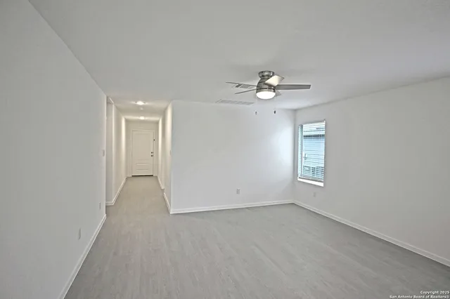 a view of a room with a ceiling fan window and a ceiling fan