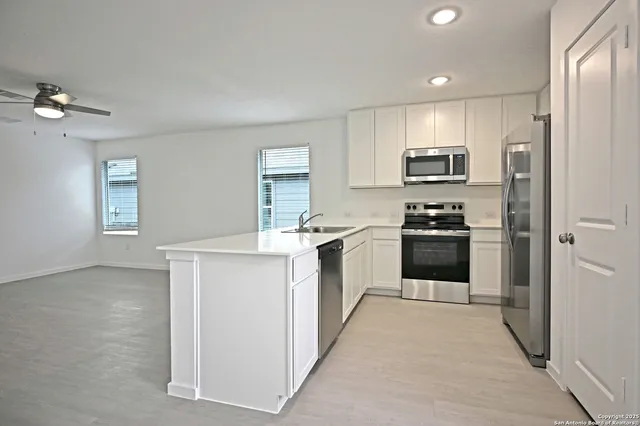 a kitchen with white cabinets and stainless steel appliances