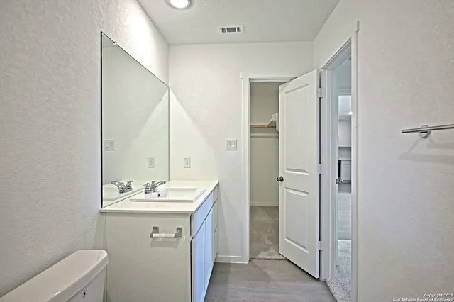 a bathroom with a sink mirror and toilet