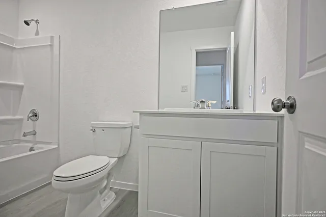 a bathroom with a sink vanity mirror and toilet