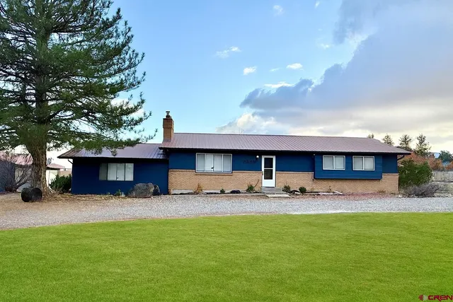 a front view of a house with a garden and yard