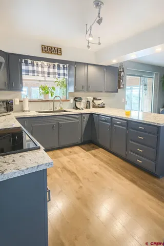 a kitchen with stainless steel appliances granite countertop a sink window and cabinets