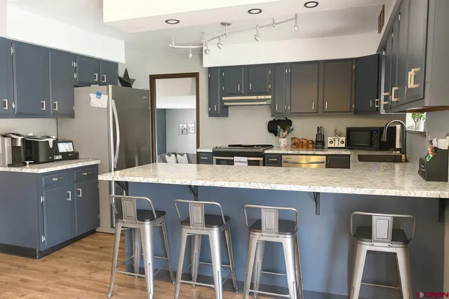 a kitchen with granite countertop stainless steel appliances a sink and cabinets