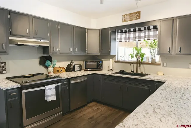 a kitchen with granite countertop a sink stove and cabinets