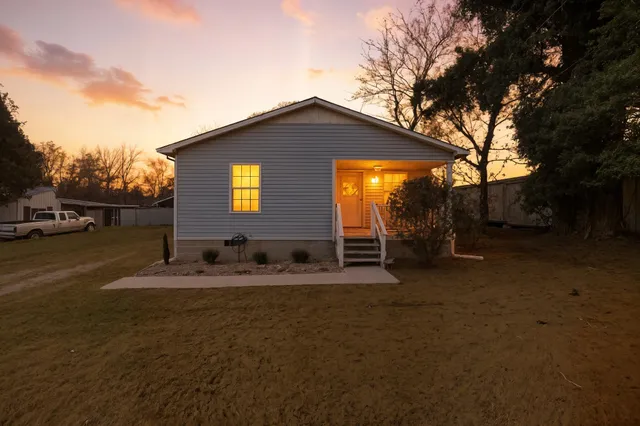 a backyard of a house with table and chairs