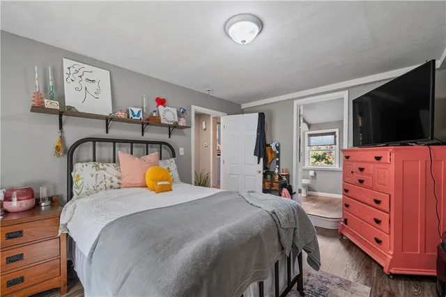 a bedroom with a bed and flat tv screen on the dresser