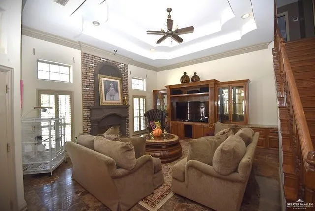 a living room with furniture a ceiling fan a fireplace and a window