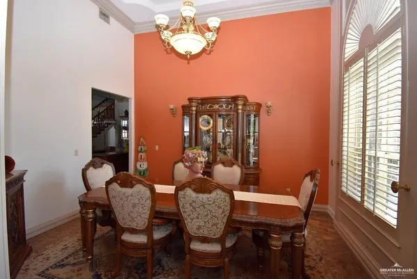 a dining room with wooden floor a chandelier a wooden table and chairs
