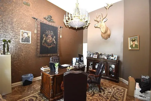 a spacious bedroom with a bed a dresser and a chandelier