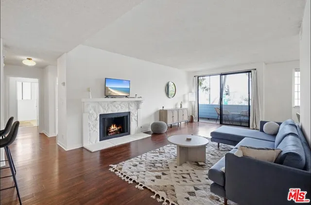 a living room with furniture a fireplace and a large window