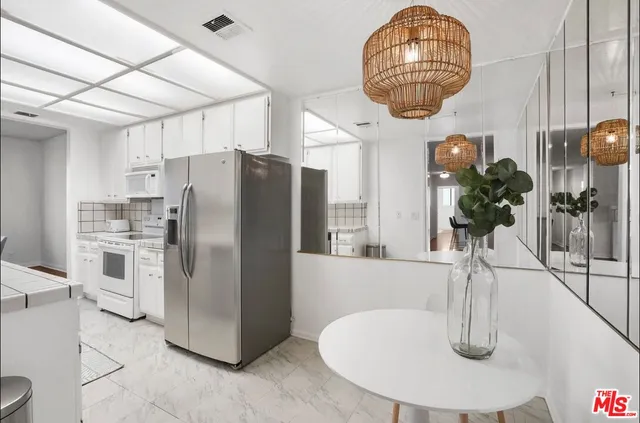 a kitchen with refrigerator a microwave a sink and cabinets