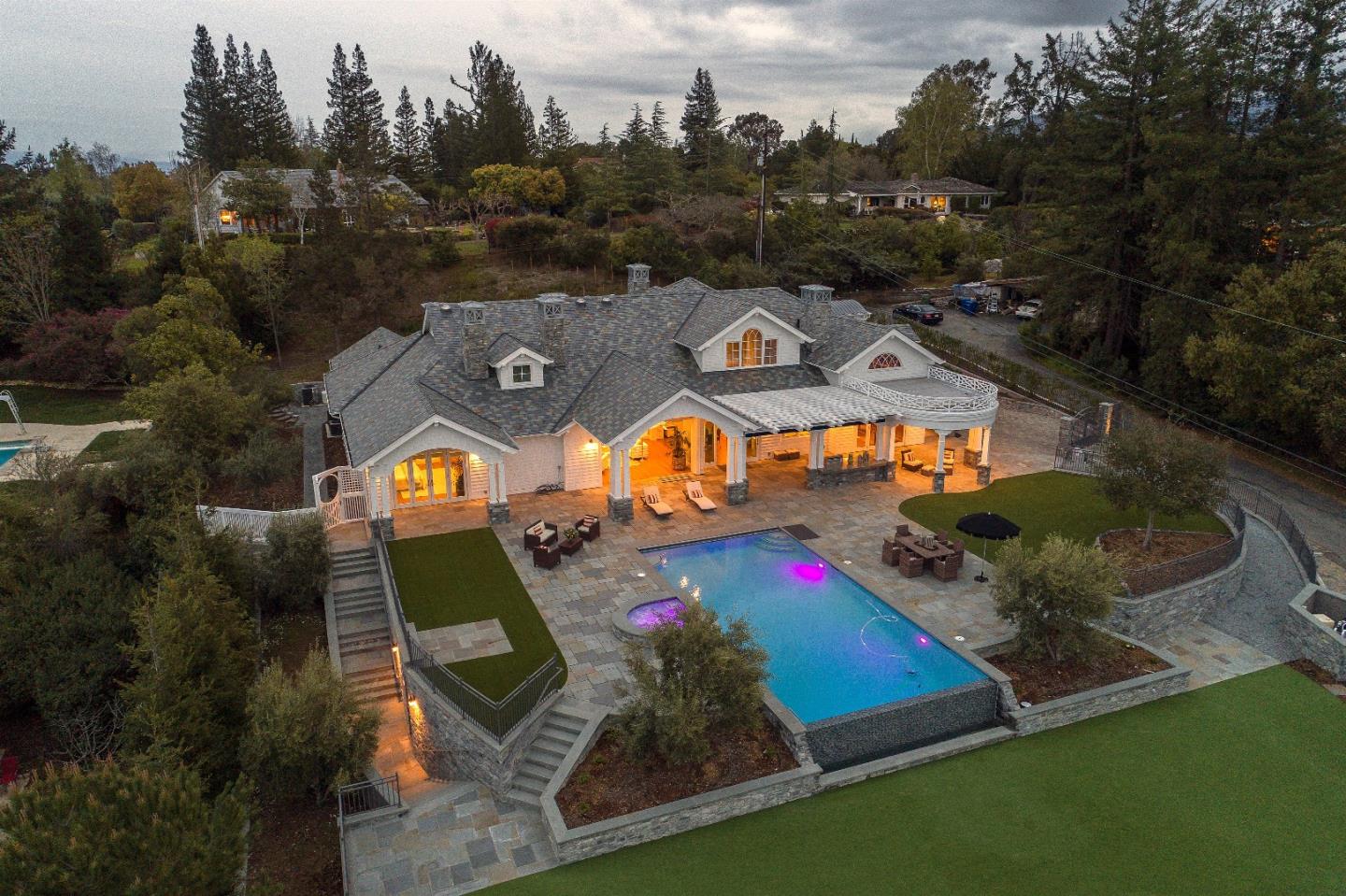 an aerial view of a backyard with swimming pool and seating space