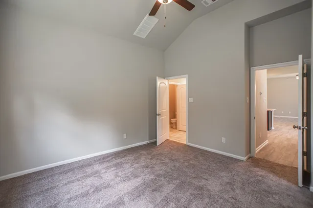an empty room that has a grey walls and fan